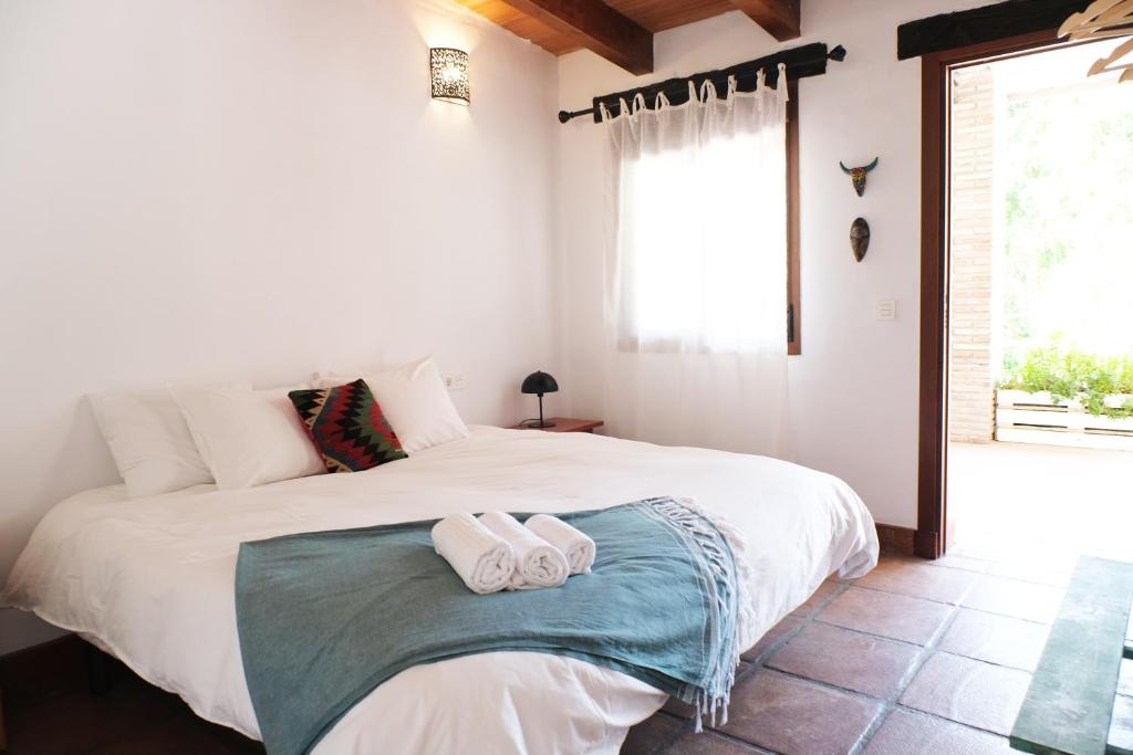 卡萨雷斯The Wild Olive Andalucía Citrus Suite的卧室配有带毛巾的大型白色床