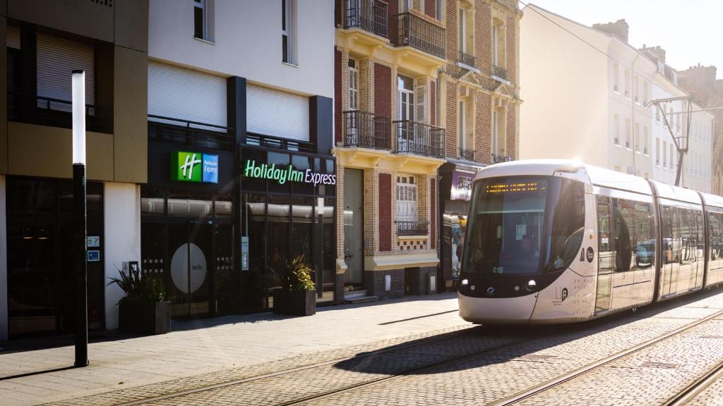 勒阿弗尔Holiday Inn Express - Le Havre Centre的城市街道上的白色电车,有建筑