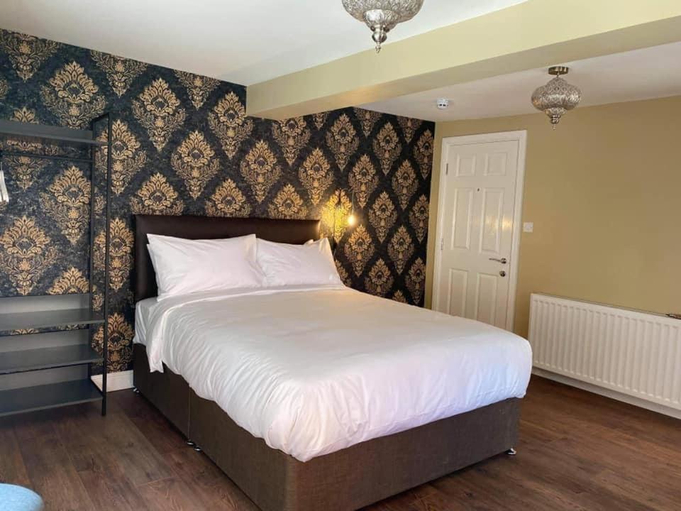 斯卡伯勒The Black Swan Hotel的卧室配有一张白色大床和墙壁