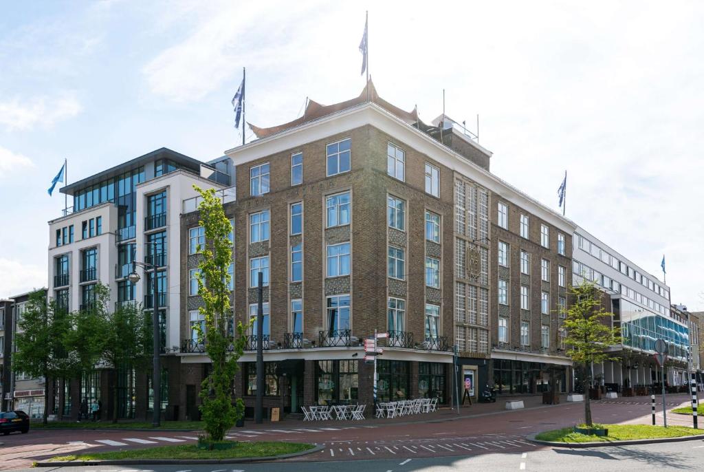 阿纳姆Hotel Haarhuis的一座大砖砌建筑,上面有旗帜