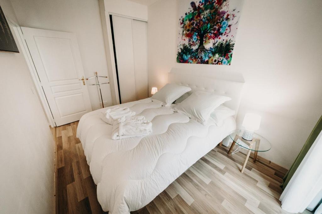 艾克斯莱班Charmant appartement 4 étoiles Bella Vita Zen的墙上画作的白色床