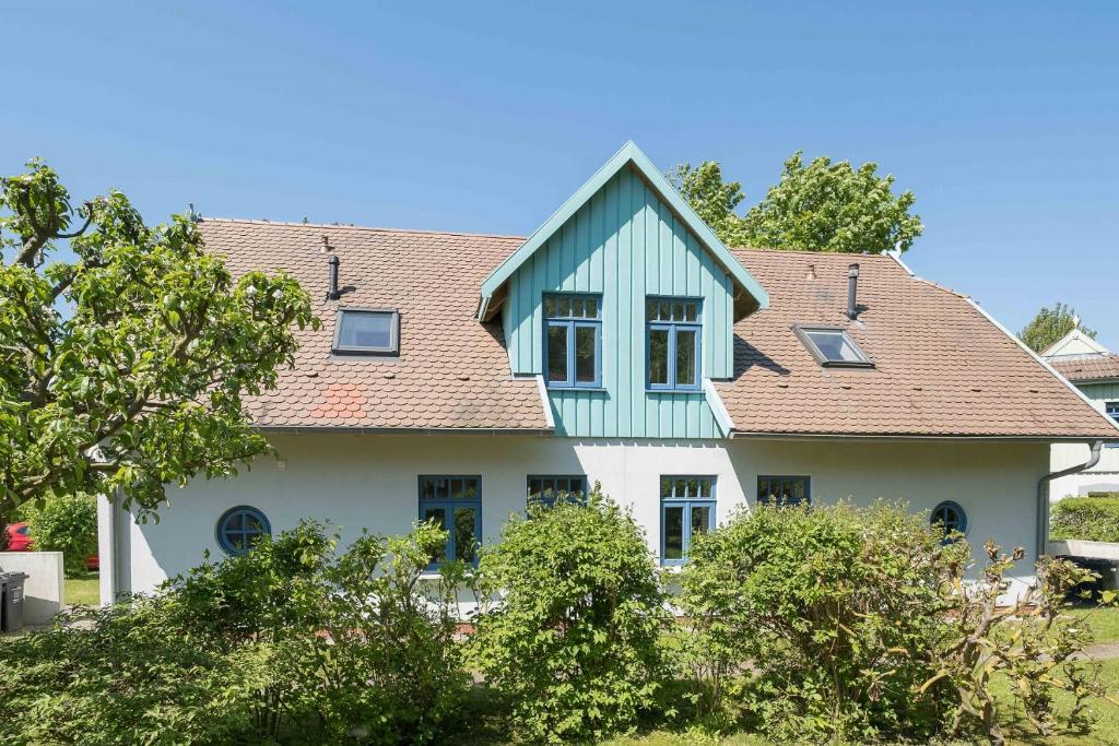欧巴德伍斯图Ferienhaussiedlung Strandperlen Weidenhof 6a (Typ VII)的蓝色屋顶的白色房子