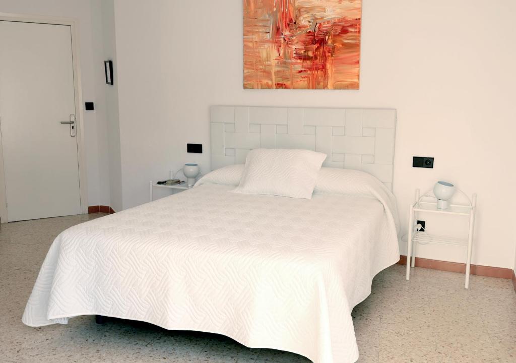 兰卡拉拉旅馆的白色卧室配有白色的床和绘画作品