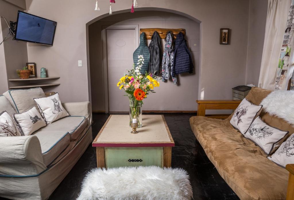 圣卡洛斯-德巴里洛切La Justina Hostel的客厅配有沙发和鲜花桌