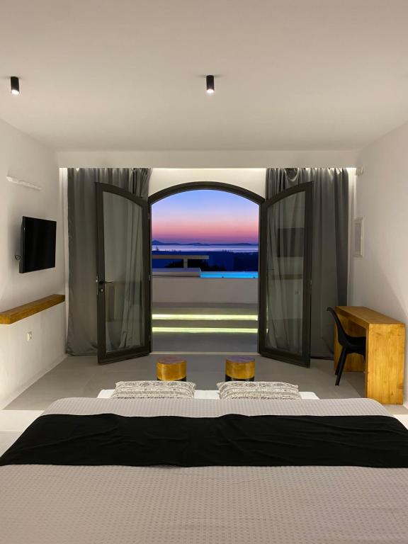 GalanádhonVilla Agrabely & Suites的一间卧室设有一张大床和一个大窗户