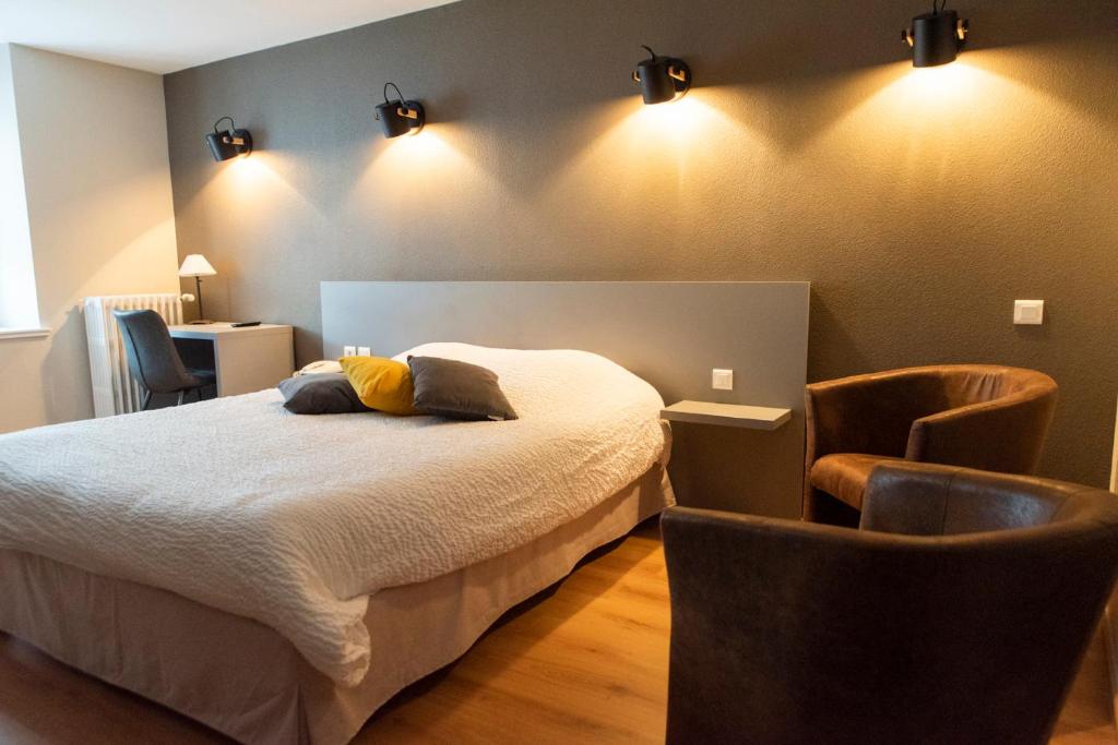 奥尔尚普韦内Logis Hôtel Restaurant Barrey的一间卧室配有一张床和两把椅子