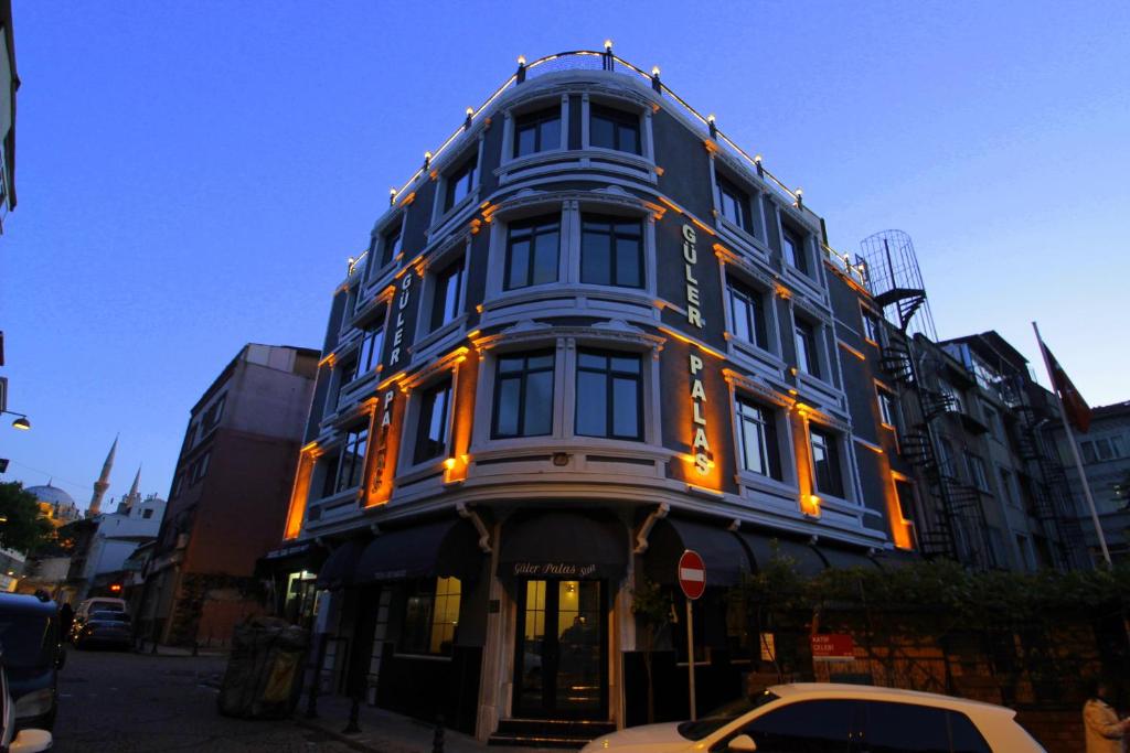 伊斯坦布尔Güler Palas Hotel的蓝色的建筑,上面有橙色的灯