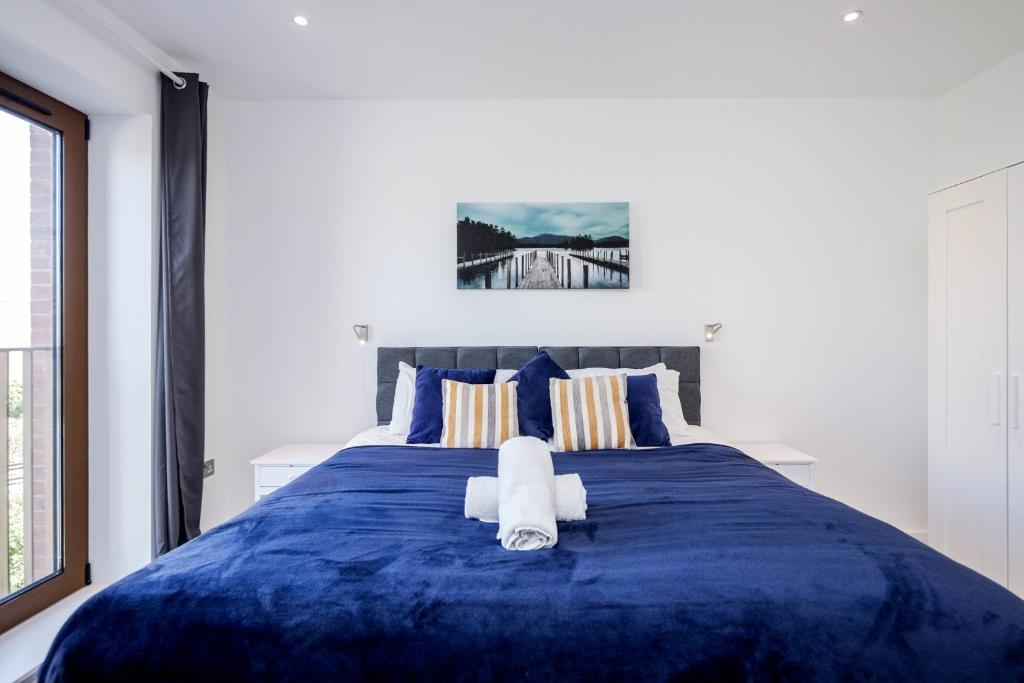 圣奥尔本斯Deluxe 1 Bedroom St Albans Apartment - Free Wifi的一间卧室配有一张蓝色的床,上面有毛巾