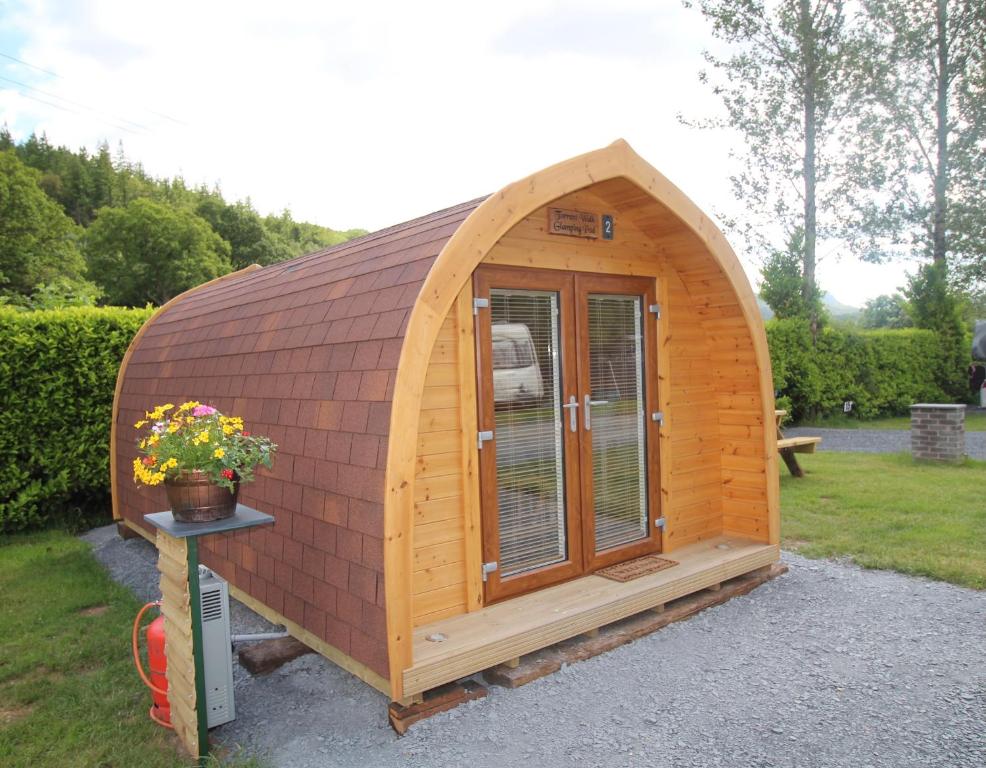 多尔盖罗Glamping Huts in Heart of Snowdonia的一座带窗户的木结构建筑,位于庭院中