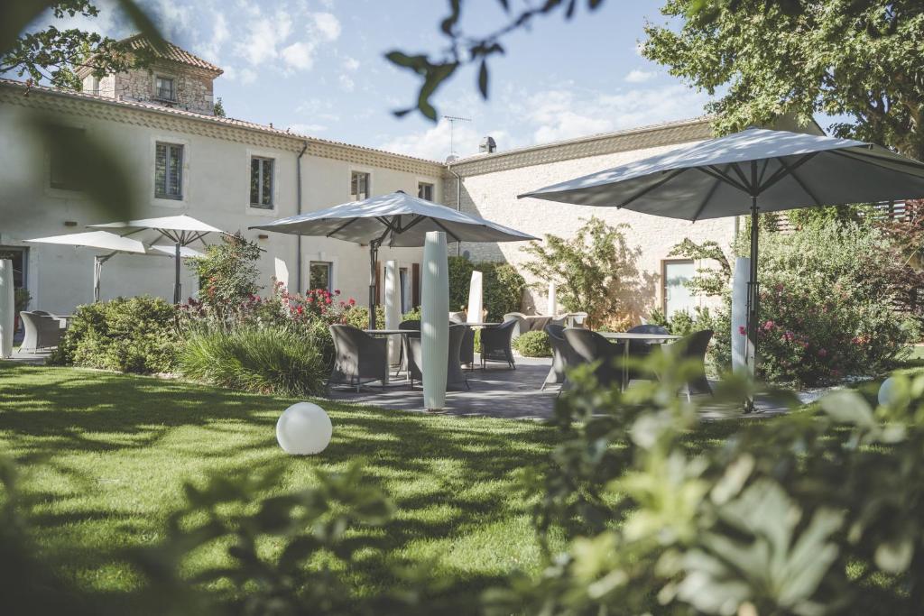 尼姆马斯德博登酒店的草地上带椅子和遮阳伞的院子