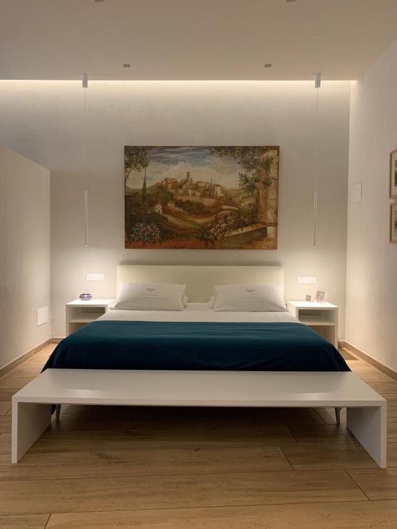 维罗纳Atto Primo Studio Apartment的卧室配有一张大床,墙上挂有绘画作品