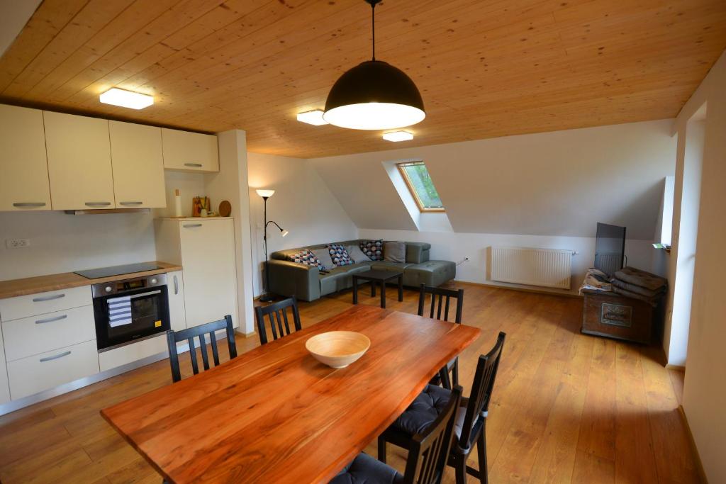 博希尼Apartmaji Pekovec Bohinj的厨房以及带木桌和椅子的用餐室。