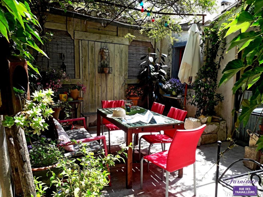 艾格-莫尔特Chambre d'hôte Farniente的一个带桌子和红色椅子的庭院