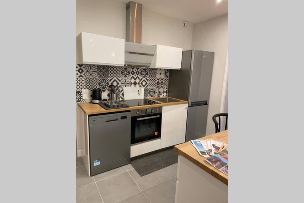 吉洛梅Appartement très spacieux & Coupery的厨房配有白色橱柜和炉灶烤箱。