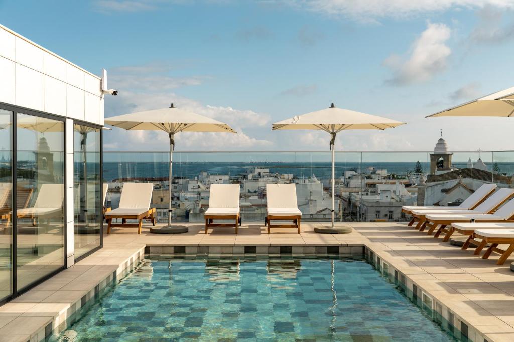 奥良Pure Formosa Concept Hotel的一座带椅子和遮阳伞的建筑屋顶游泳池