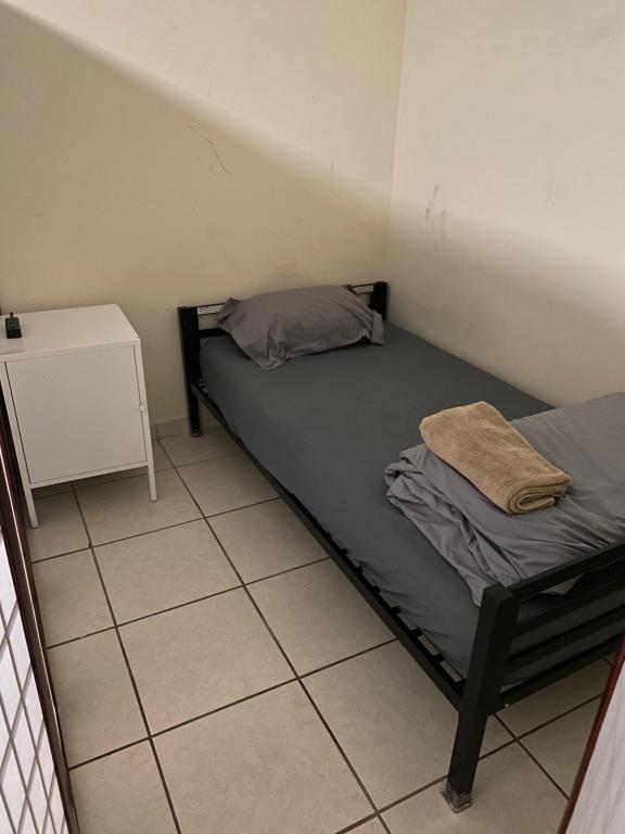 迈阿密Private Cubicle - Single Bed - Mixed Shared Dorm - MIAMI AIRPORT的小房间,设有床和床头柜