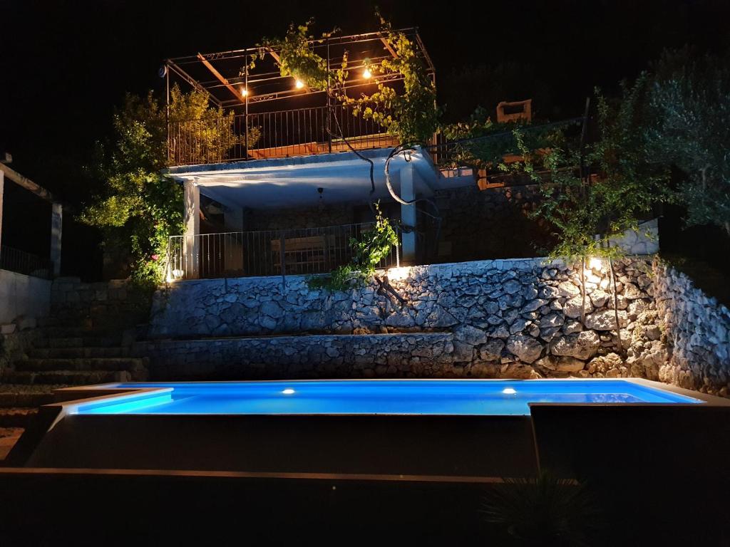 DrašniceVilla Jerković-Secluded house and apartment with pool的一座带石墙的夜间游泳池