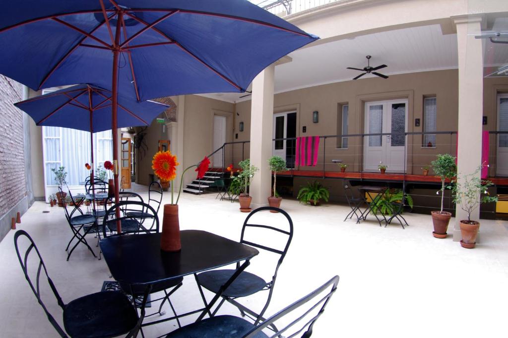 布宜诺斯艾利斯巴迪欧斯圣铁莫酒店的一个带桌椅和遮阳伞的庭院。
