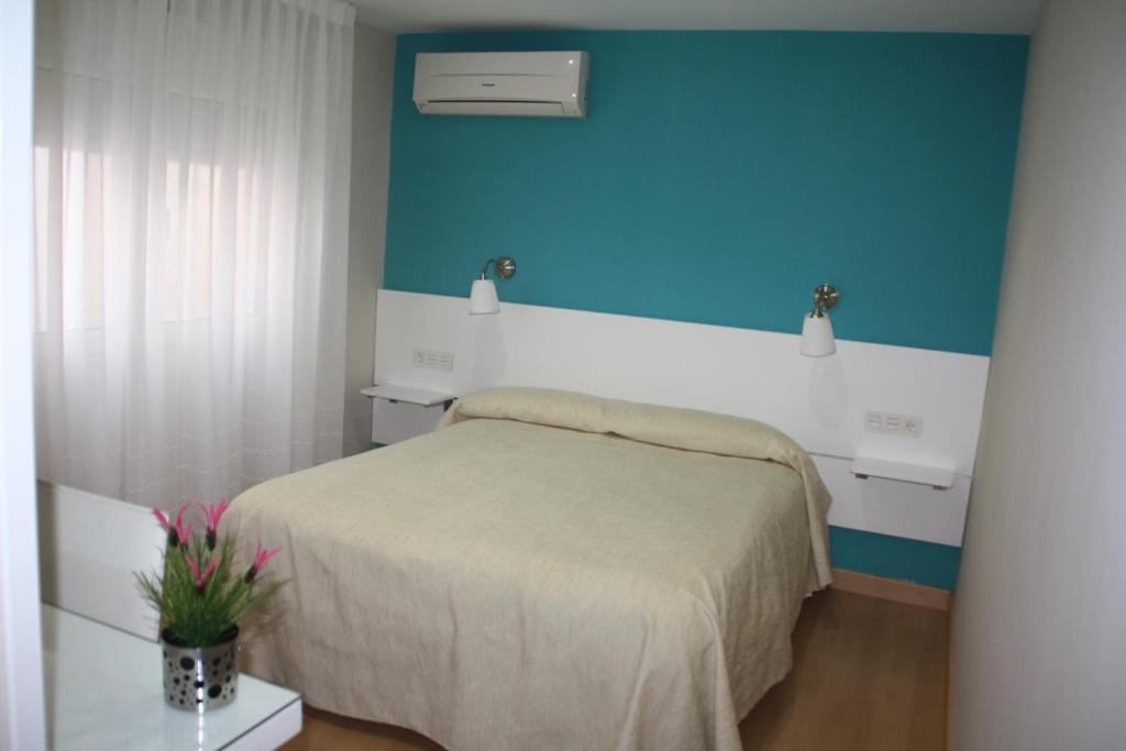 格拉纳达Verona的一间卧室设有一张床和蓝色的墙壁