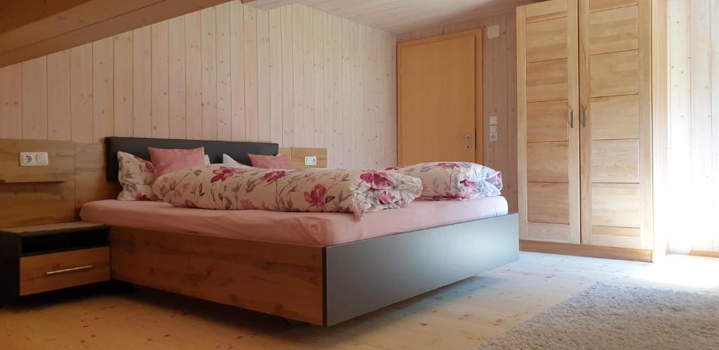 Schnepfau豪斯福伊尔斯坦公寓的一间卧室配有一张粉红色床单。
