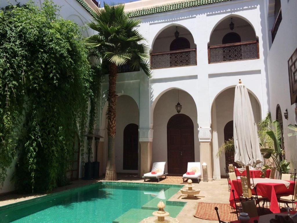 马拉喀什雷亚德夏玛套房酒店及Spa的一个带游泳池和大楼的庭院
