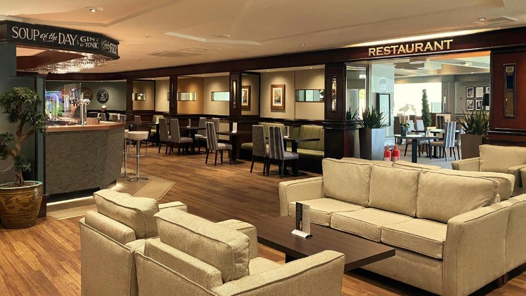 佩斯利Normandy Hotel (Near Glasgow Airport)的一个带沙发和桌子的大堂以及一间餐厅