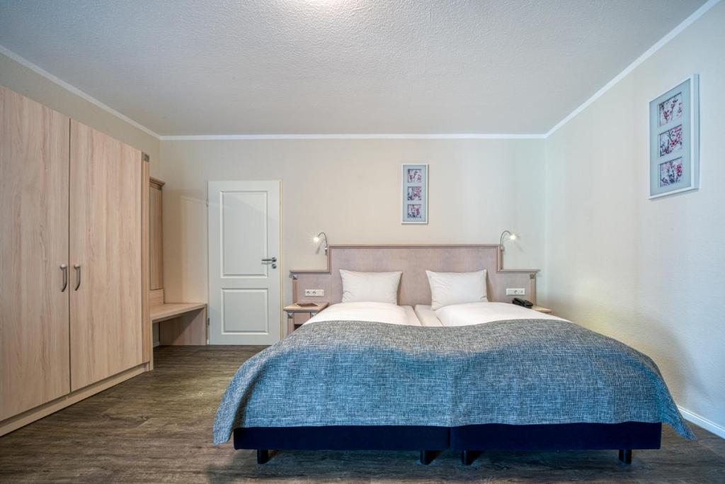 帕彭堡FF&E Hotel Engeln的一间卧室配有一张带蓝色毯子的大床