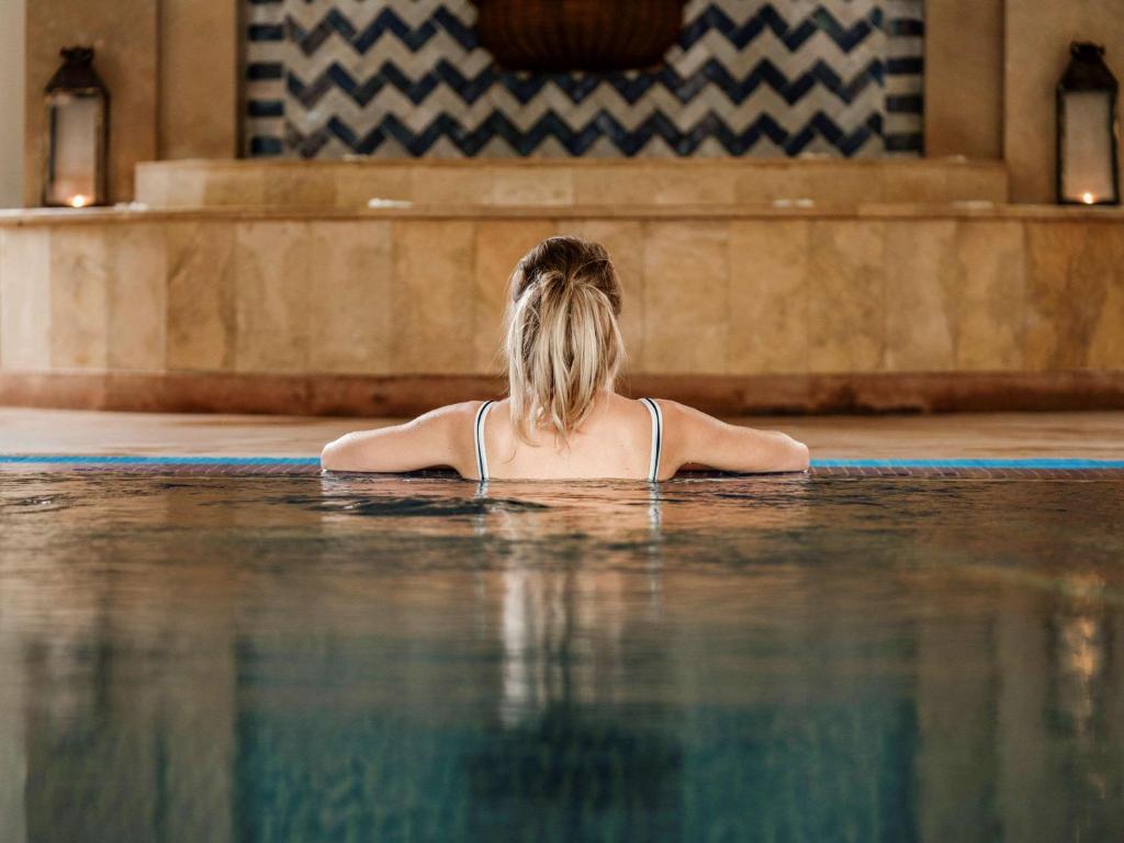 索维拉Hotel Le Médina Essaouira Thalassa sea & spa – Mgallery的坐在游泳池的水中的女人