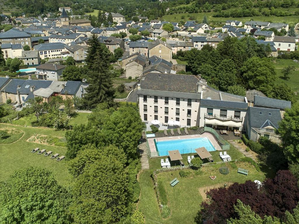 梅吕埃Logis Hôtel Restaurant Le Mont Aigoual的享有带游泳池的建筑的空中景致