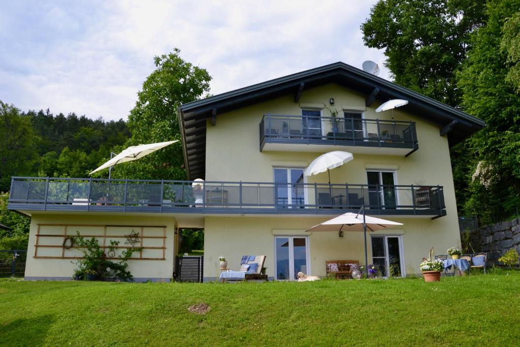 沃尔特湖畔韦尔登Schwalbennest Velden的带阳台和草坪的度假屋