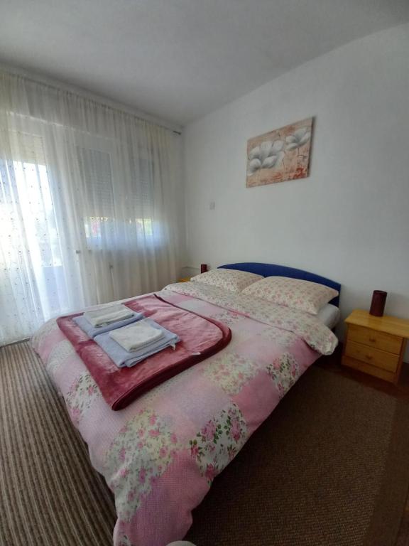 Vrhovine韦利科农家乐的一间卧室配有一张床铺,床上铺有粉色毯子