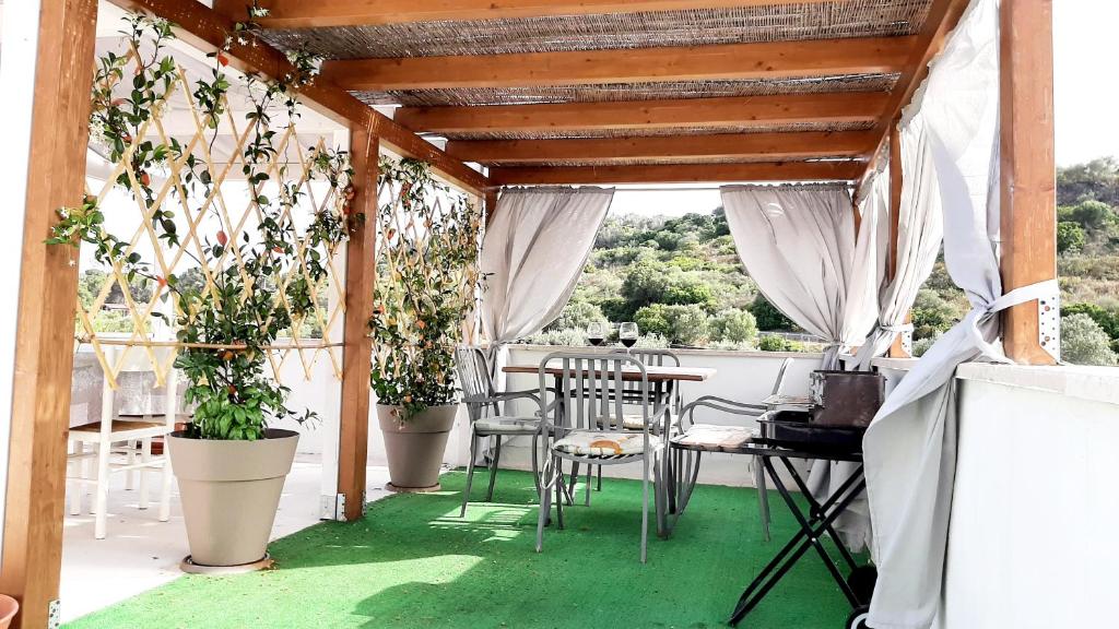 卡拉·利贝罗托viale Marzellinu的一个带桌椅和盆栽的庭院