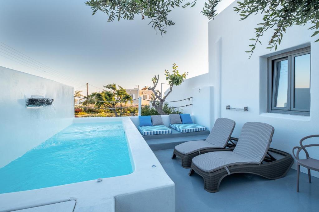 梅加洛克里Majestic Sky Luxury Suites的一座带两把椅子的房子内的游泳池
