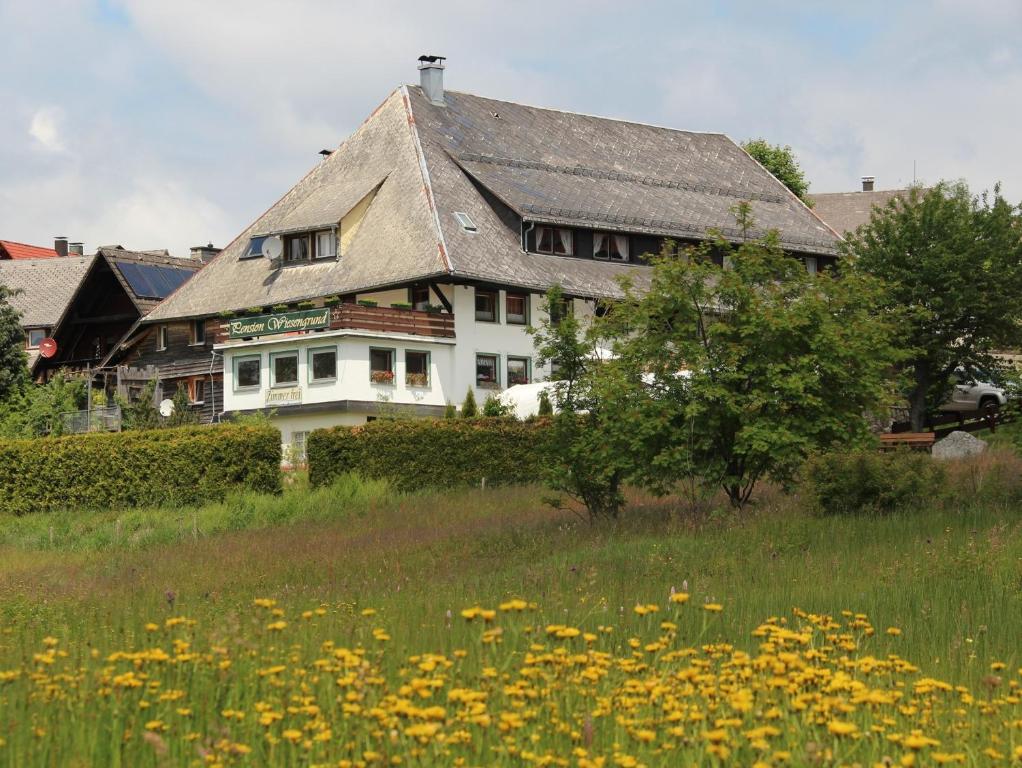 施卢赫湖维森格伦德膳食公寓酒店的坐在花田上的大型白色房屋