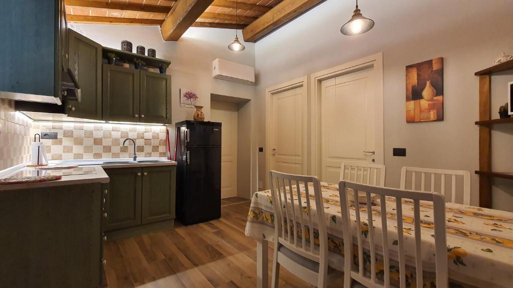 圣吉米纳诺Appartamenti Tinacci的一间厨房,内设绿色橱柜和一张婴儿床