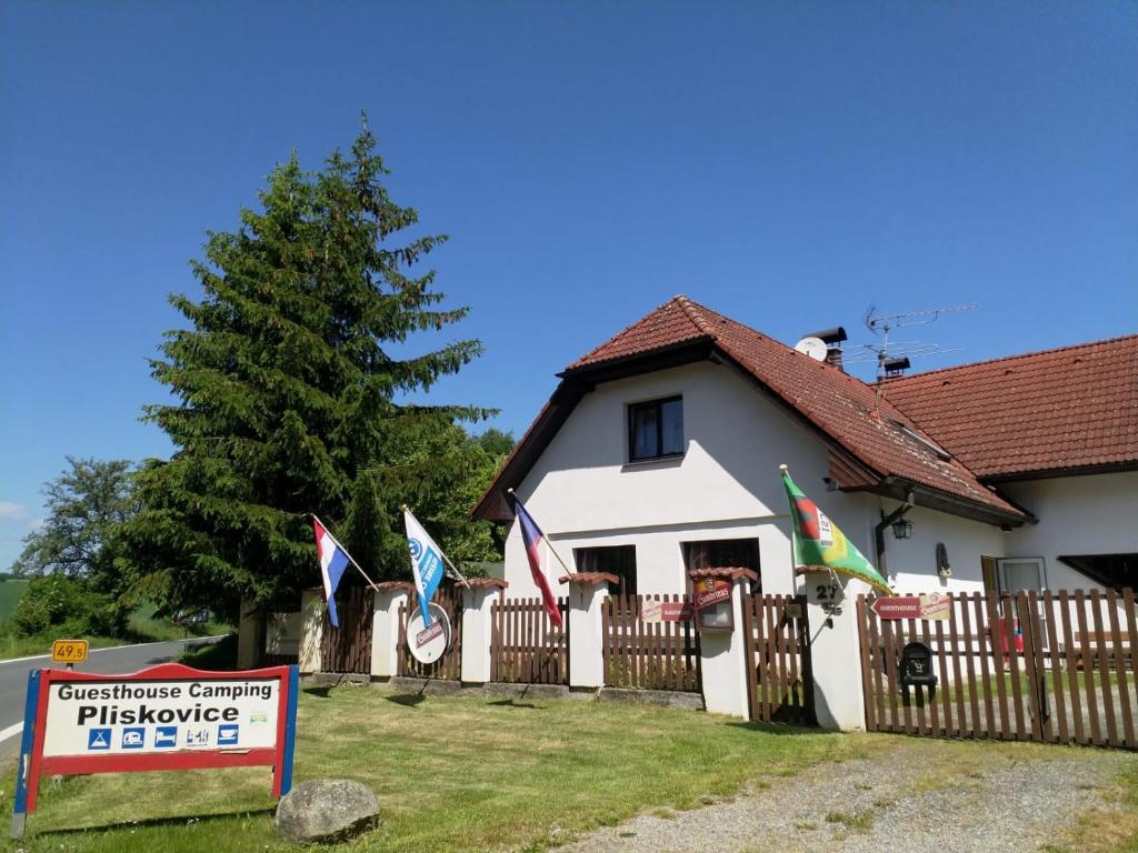 MiroviceCamping & Guest House Pliskovice的前面有一面带旗帜的栅栏的房子