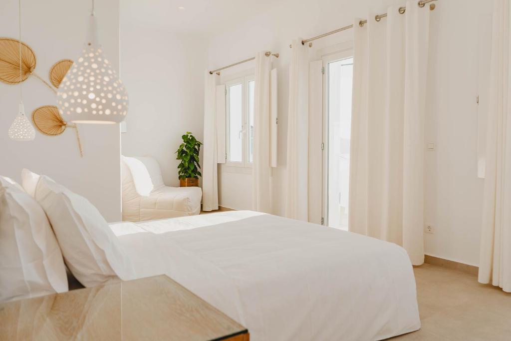 米克诺斯城BAY VIEW RESIDENCE的白色卧室配有白色的床和椅子