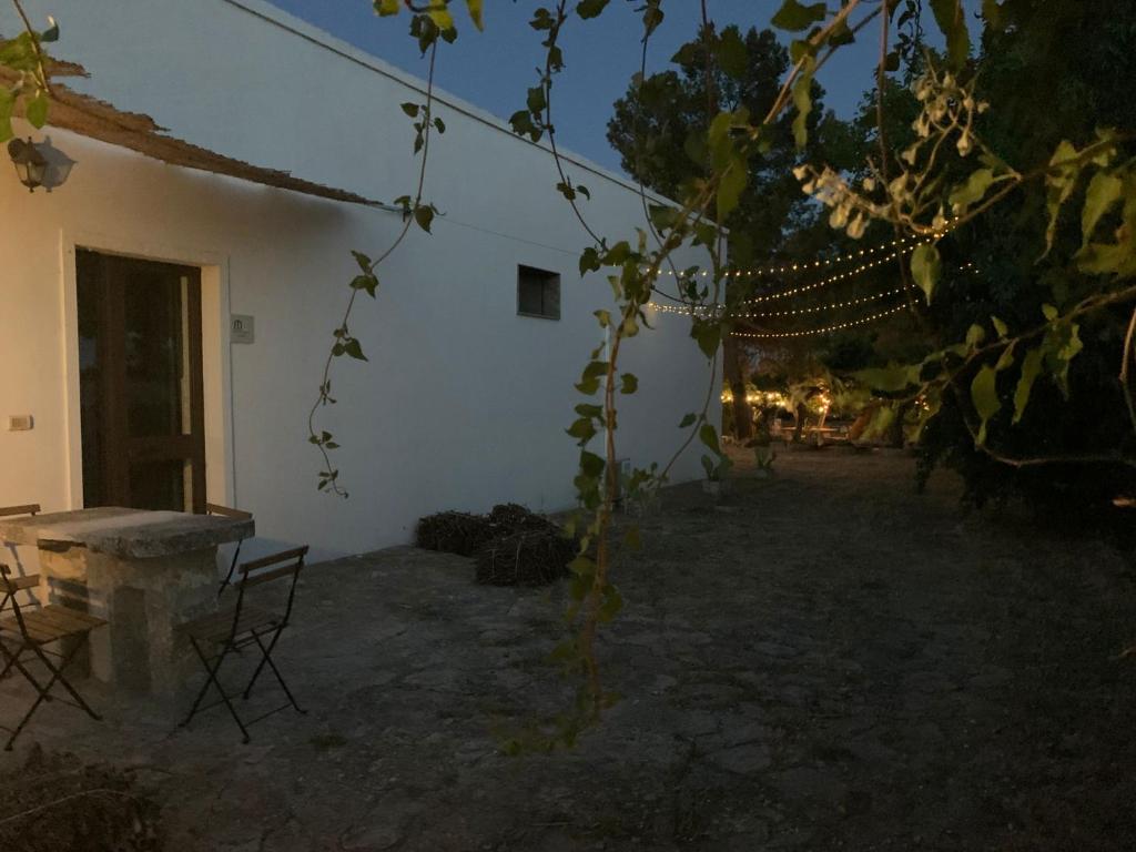 莫托拉masseria chianca " Le Gravine"的一座白色的建筑,在院子里设有桌椅