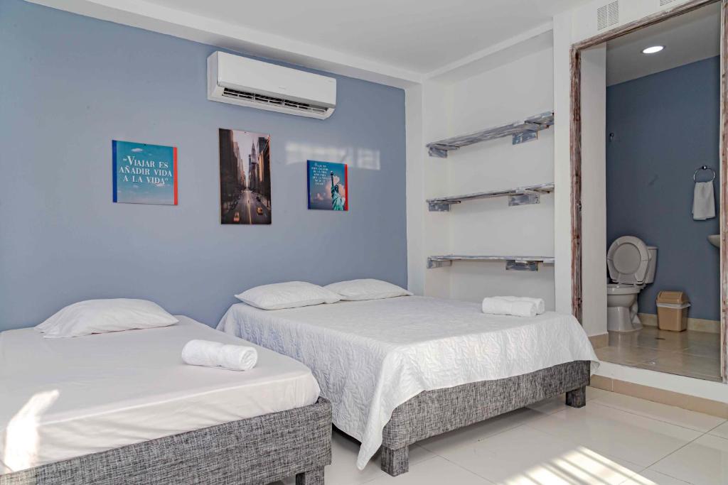 卡塔赫纳Luna Cartagena Airport Hotel的蓝色墙壁客房的两张床