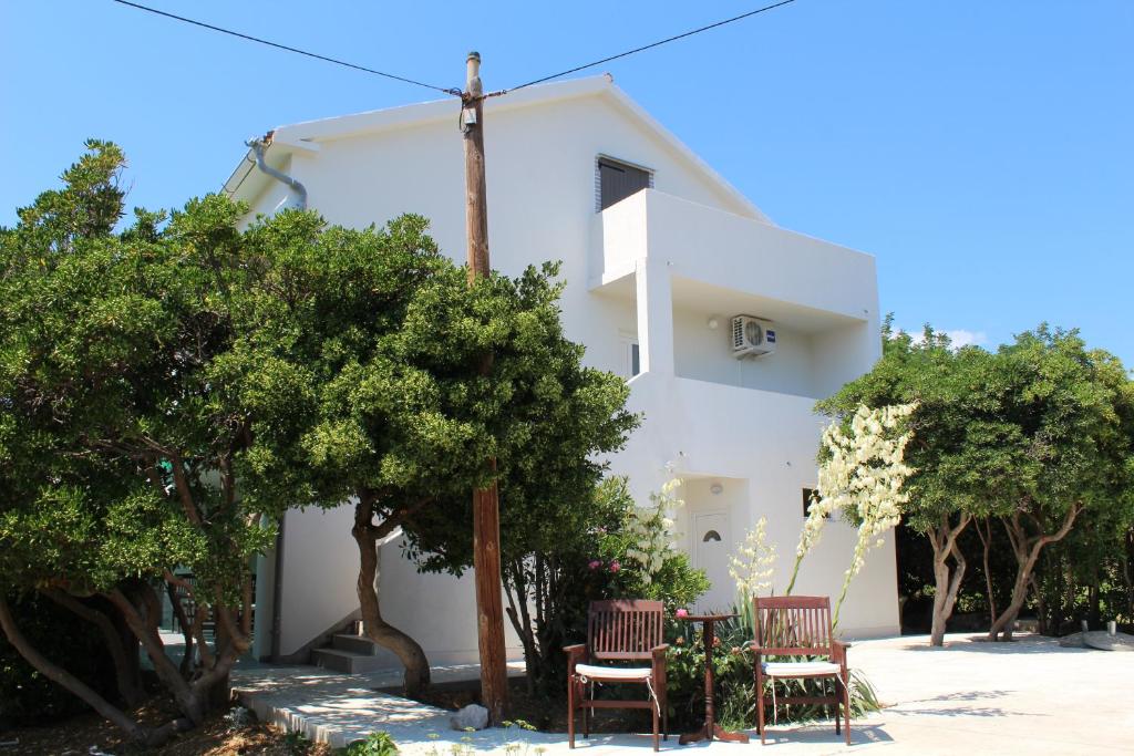 帕格Apartman Boki的白色的房子,两把椅子和树木