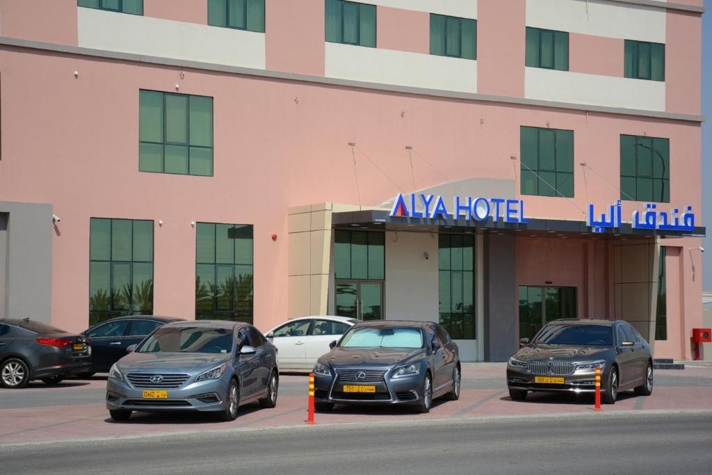 拜尔卡ALYA Hotel的停在大楼前的一组汽车