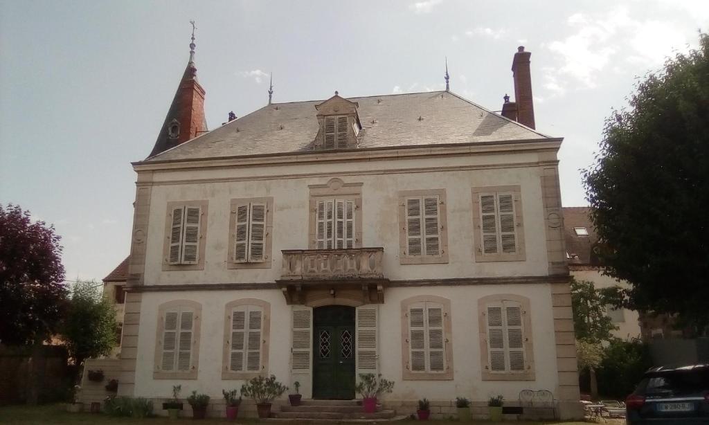 SeurreManoir de la Saône的一座白色的大建筑,设有钟楼