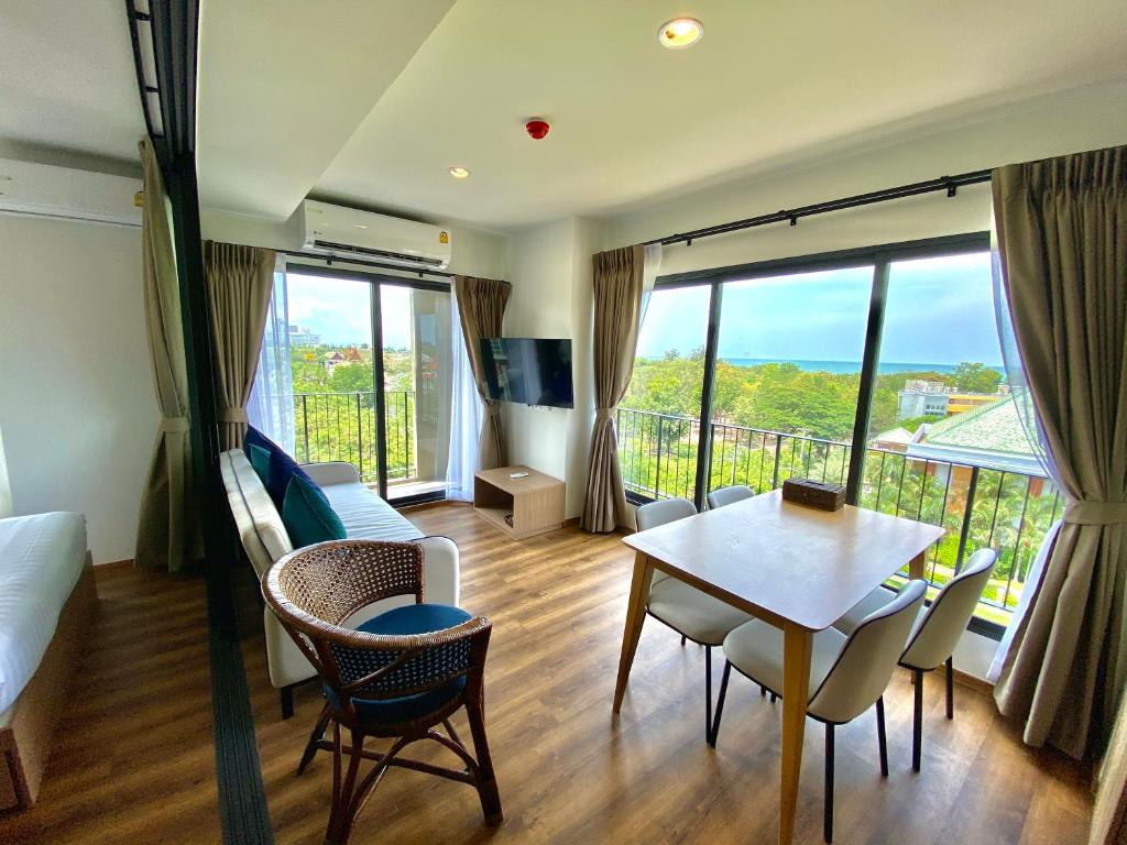 华欣La Habana Hua Hin 2 Bedroom Seaview的客厅配有床和桌椅