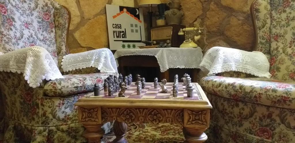 艾利翁BOTEROS casa rural的一张桌子上的棋盘,房间里有两把椅子
