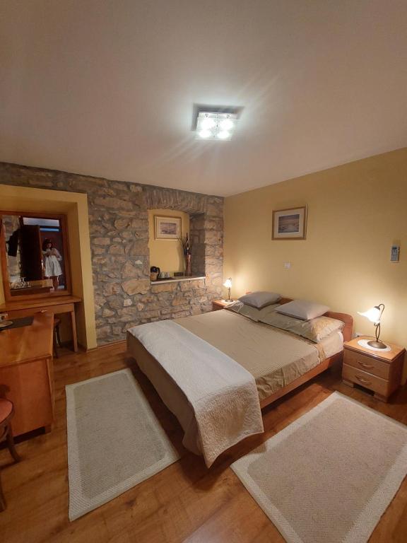 普利莫顿Guest house Paola的一间卧室设有一张大床和石墙