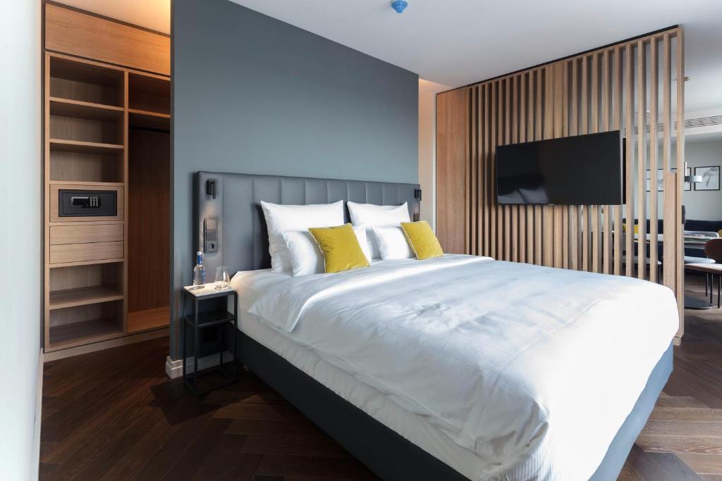 哈尔伯格摩斯SOLLER Business Hotel - Munich Airport MUC的一间卧室配有一张带黄色枕头的大床