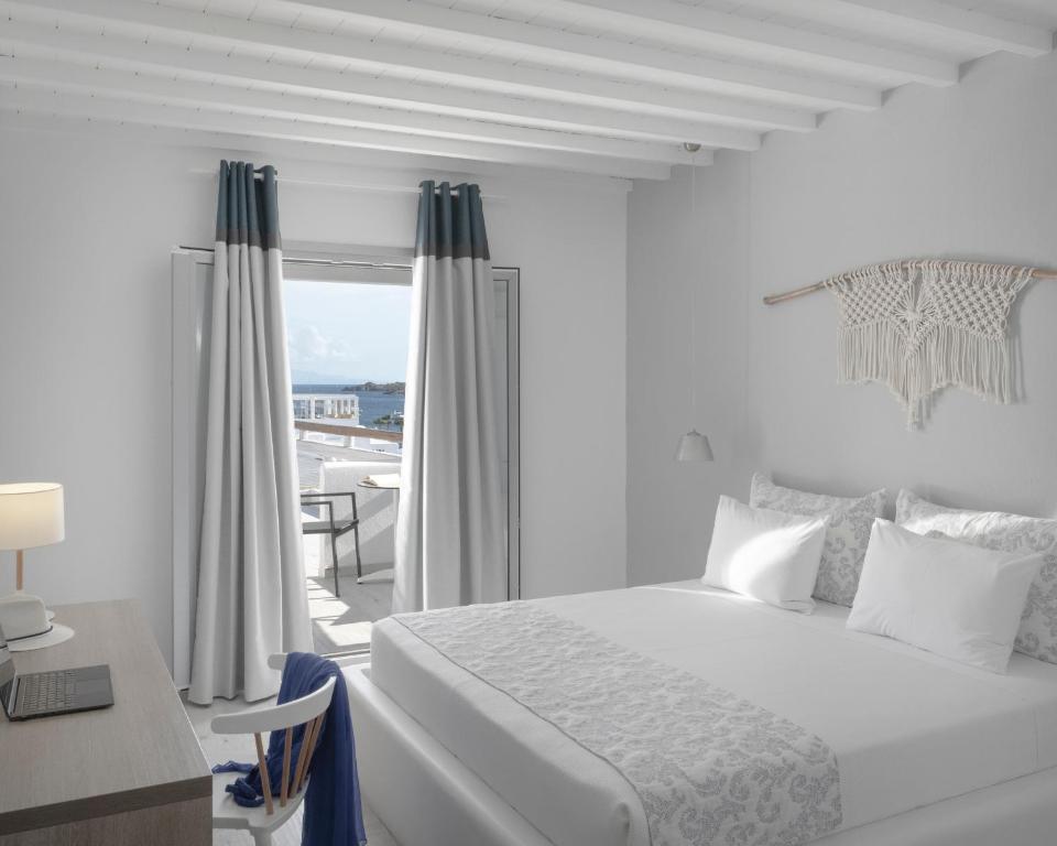 奥诺斯Mykonos Essence Adults Only的白色的卧室设有床、书桌和窗户