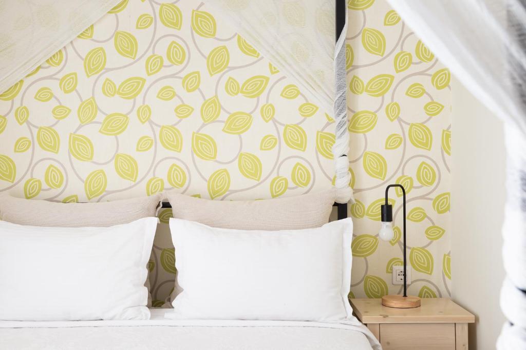 奥林匹亚达德国酒店的一间卧室配有带白色枕头的床和床头板