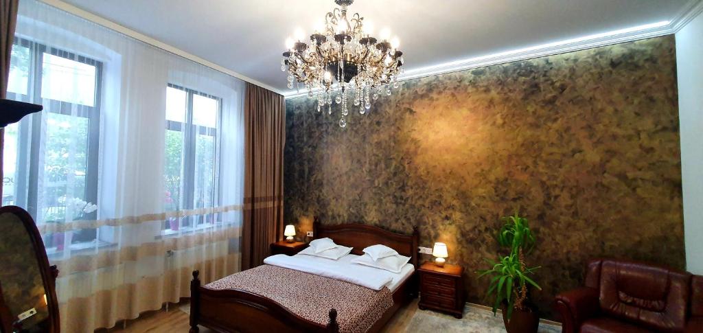 坎普朗莫道尼斯Casa Domnească Rarau的一间卧室配有一张床和一个吊灯