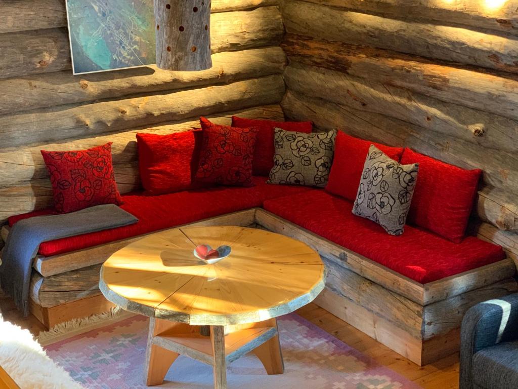 洛斯托Logwood Chalet的客厅配有红色的沙发和桌子